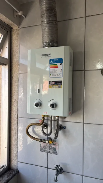 Aquecedor a gás Komeco Slim KO 07M BP instalado, com registro de gás e ligações de água