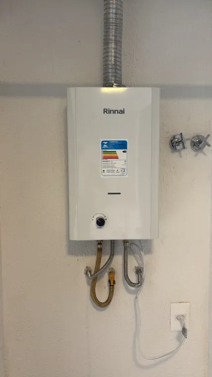 Aquecedor a gás Rinnai instalado, com duto de exaustão e ligações de água e gás em flexível